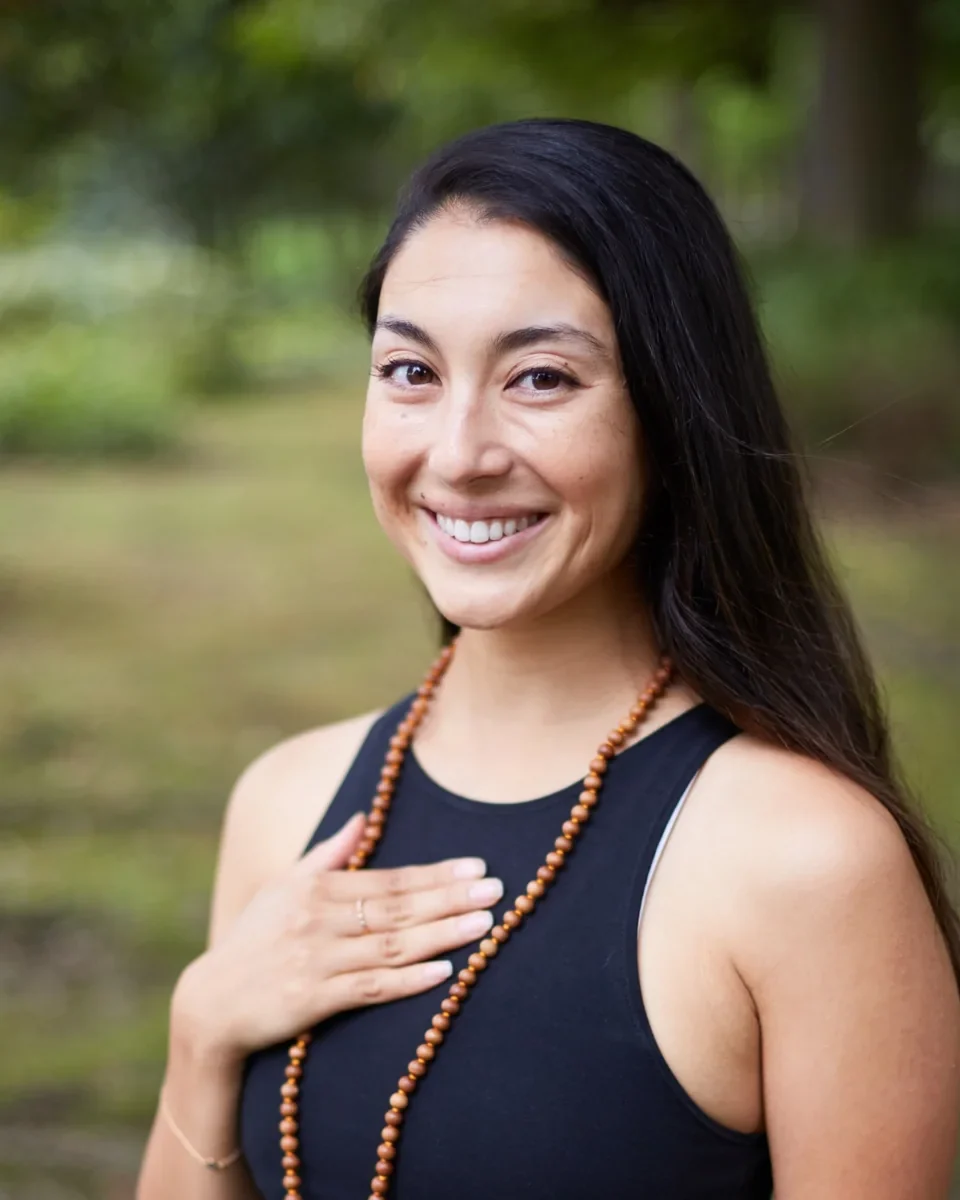 Portrait of Miné smiling with her hand over her heart