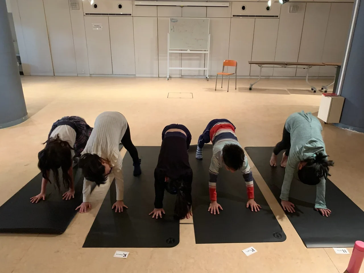 Children taking part in a yoga and mindfulness class on mats