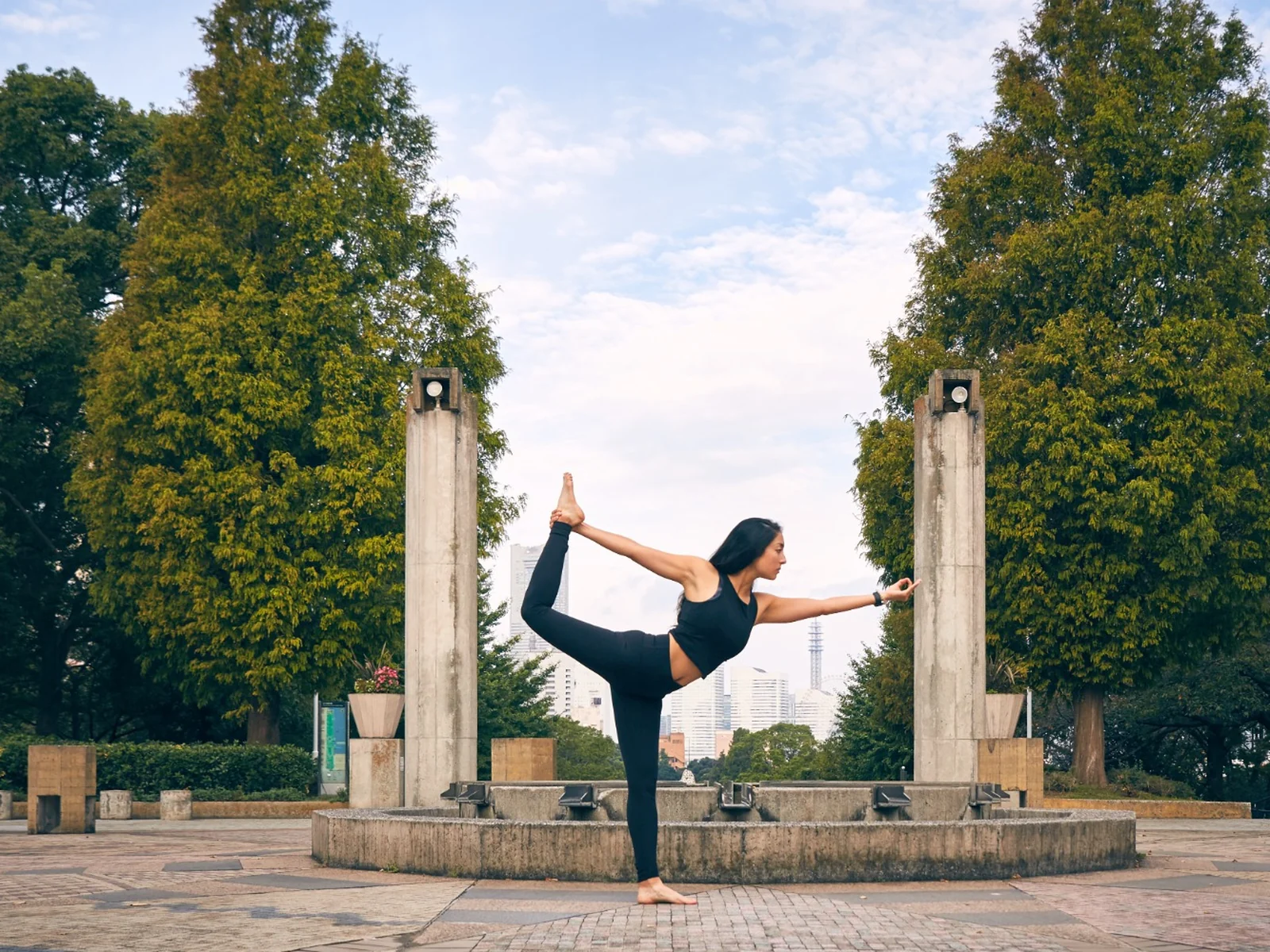 Miné practicing a balancing yoga pose outdoors